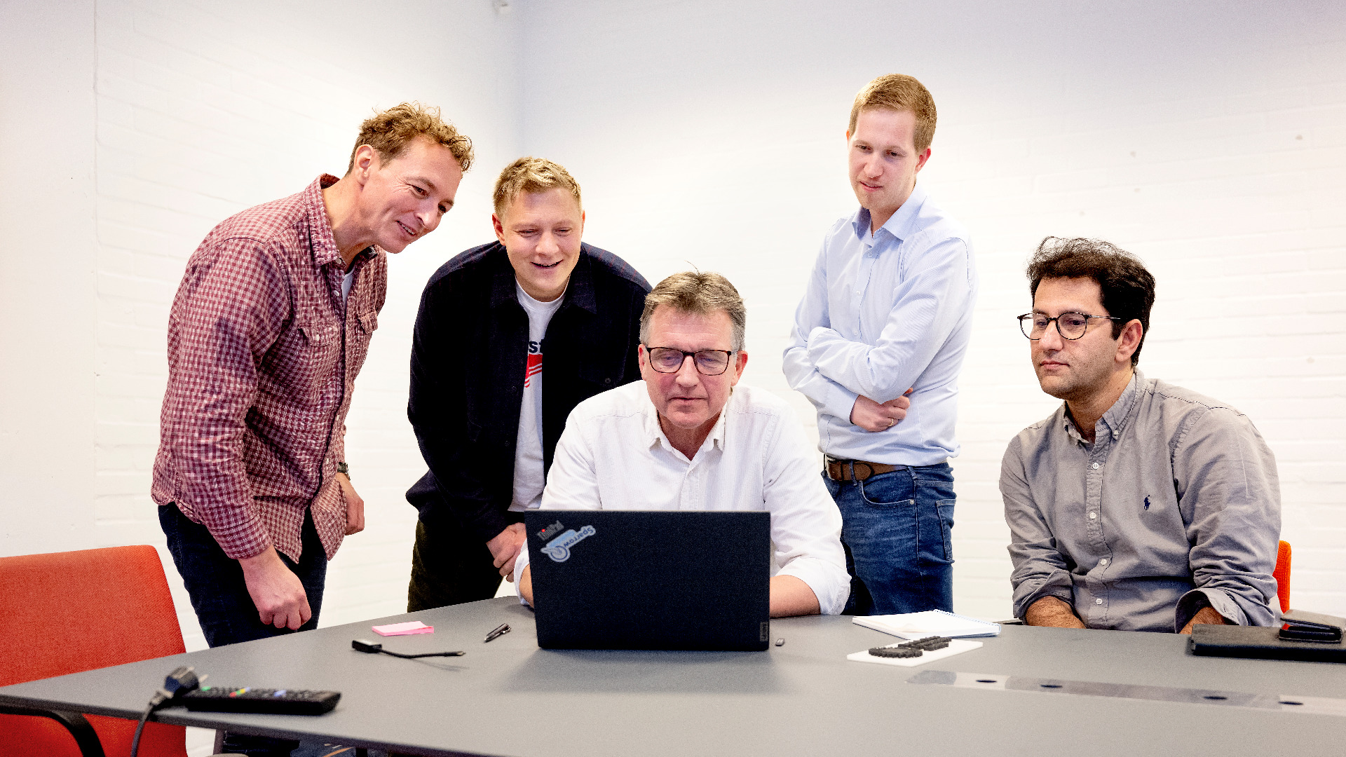 Foto af Claus Friis Pedersen, Farshad Moradi og andre, der sammen kigger på en computerskærm